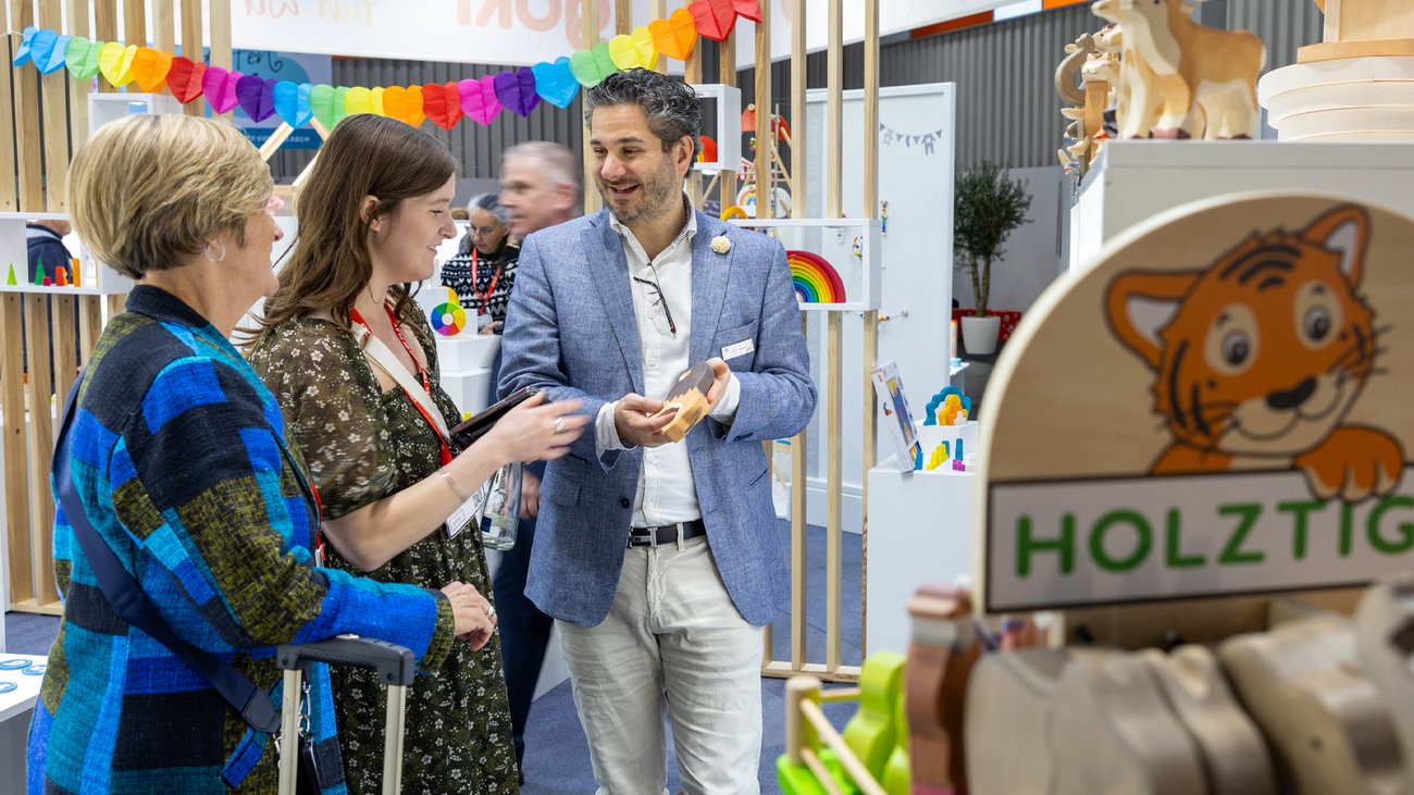 Exhibitor talking to invited customers at a stand during a sales pitch.