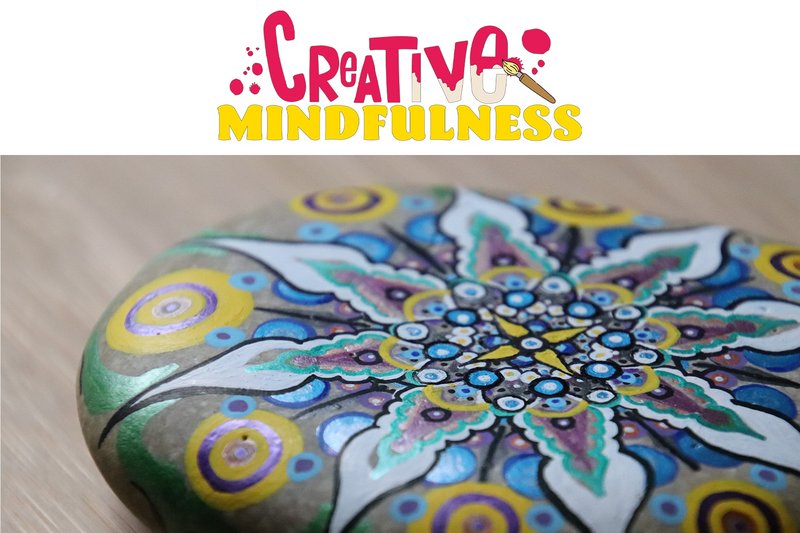 A stone painted with a mandala, with the 'Creative Mindfulness' logo brushed above it.