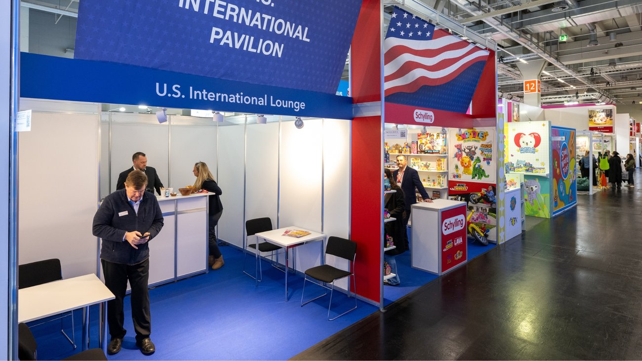 US International Lounge und bunter Spielwarenstand mit amerikanischer Flagge auf der Messe.